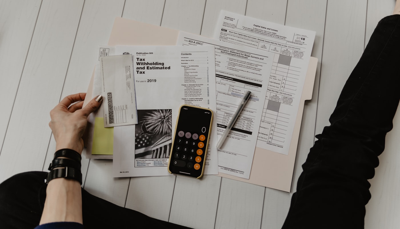 Payroll and tax paperwork with a calculator on a desk